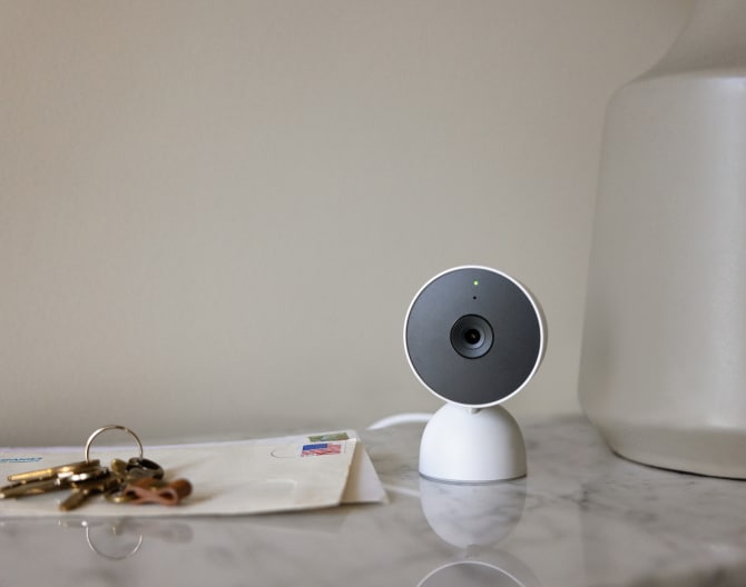 Google Nest Cam (Indoor) on a table next to house keys and mail