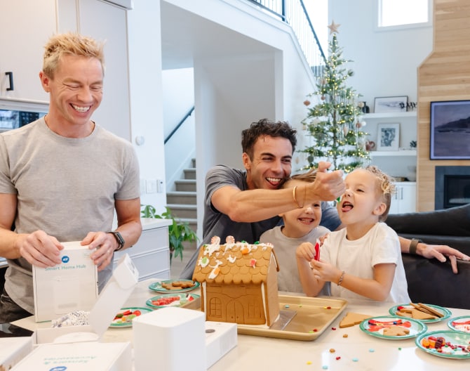 Family making a gingerbread house and opening ADT products