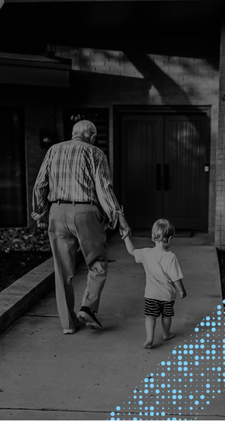 Abuelo e hijo caminando juntos por la acera y tomados de la mano