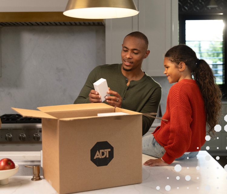 A man and woman opening their ADT package on a counter