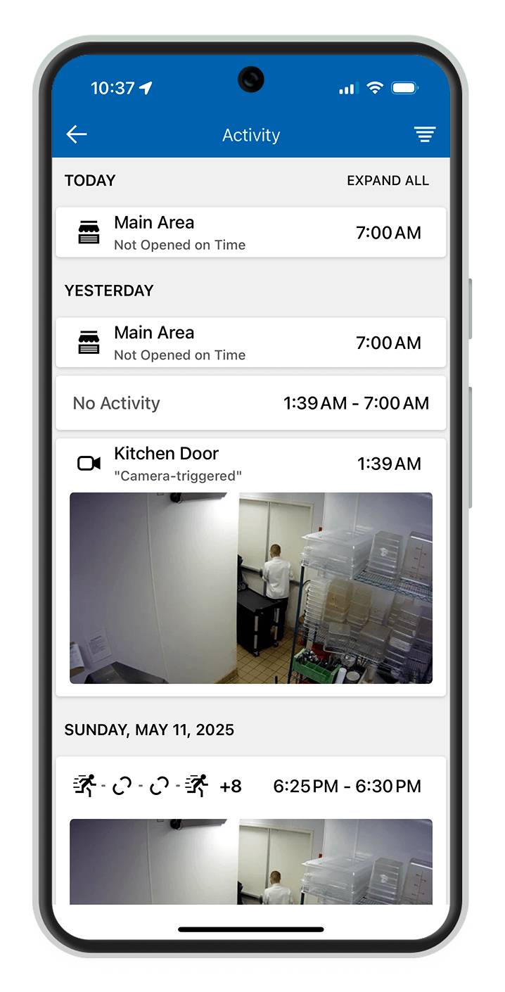 ADT sign on yard A smiling business owner in a yellow shirt and apron stands in a well-lit café, holding a tablet to manage operations.