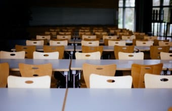 Perspective view of school tables and empty chairs