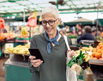 Woman using the ADT app on her phone in the grocery store