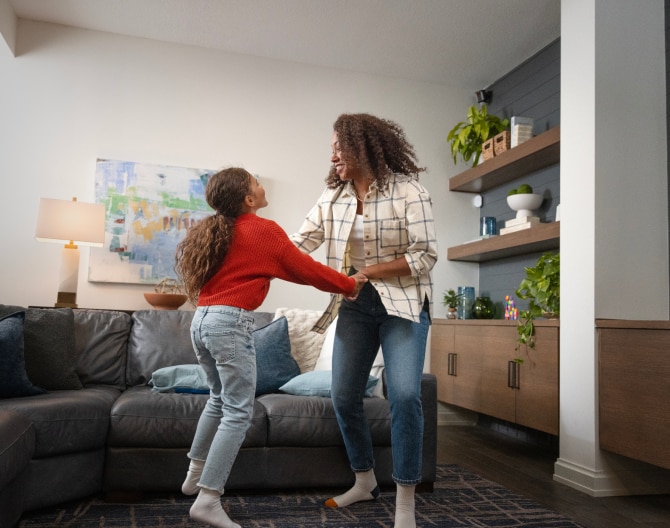 Mother and daughter dancing in the living room with an ADT Motion Sensor installed