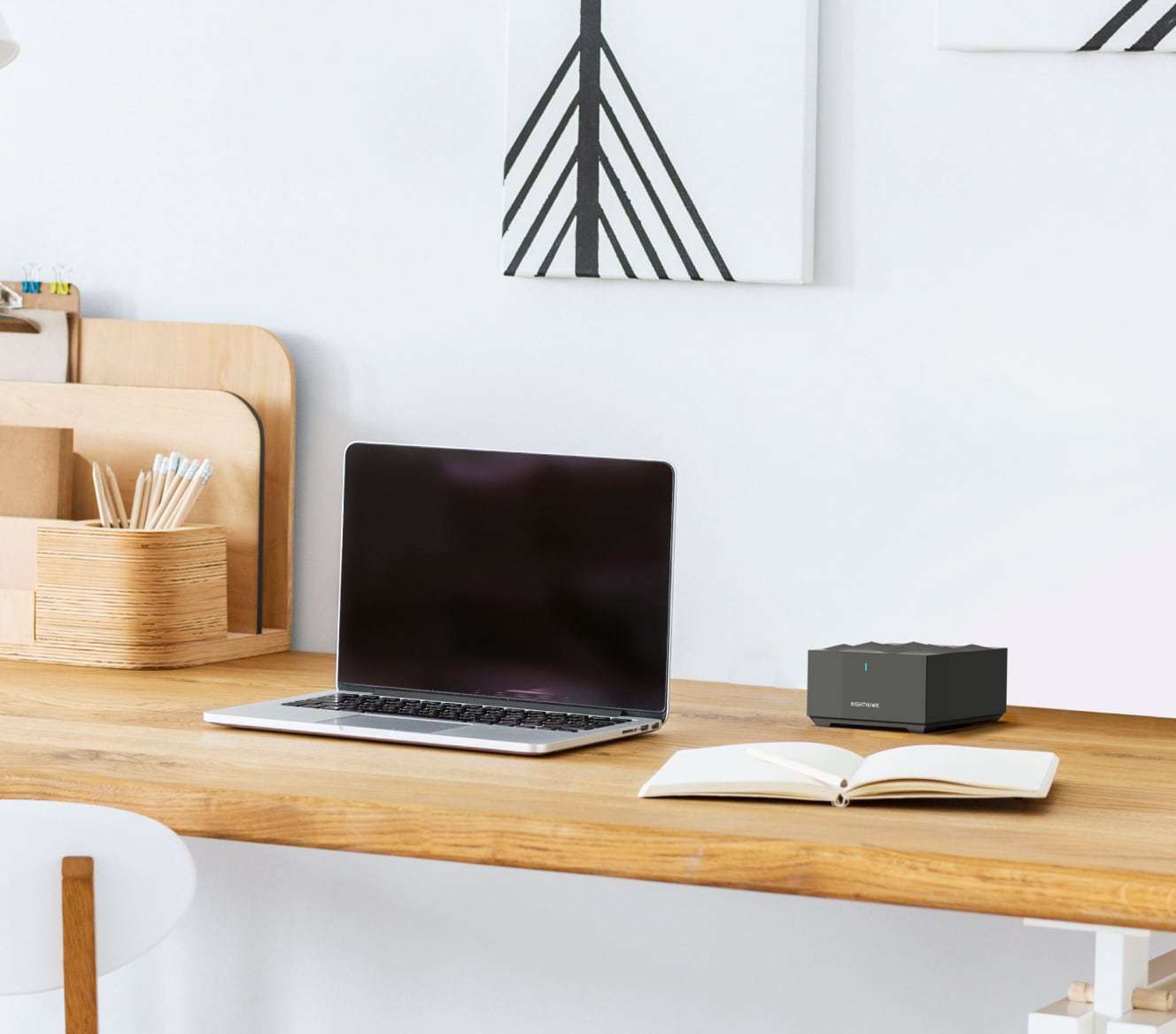 Netgear Mesh WiFi on a wooden desk next to a laptop and notebook