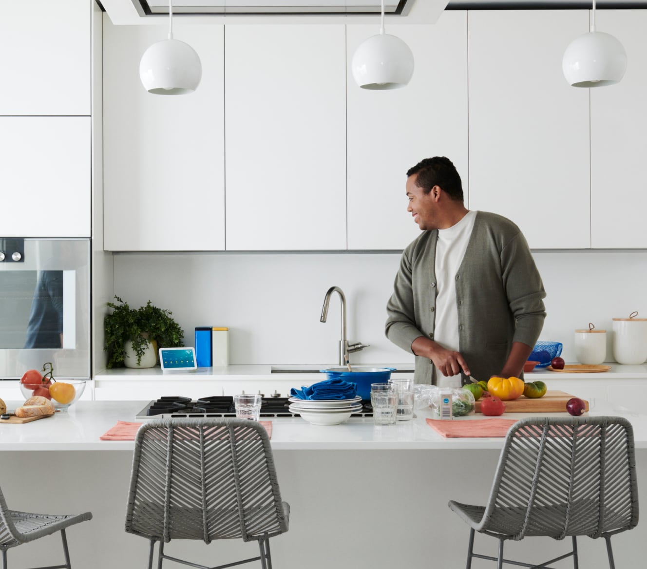 Hombre usando el control por voz con su Google Nest Hub, 2 generación, en la cocina