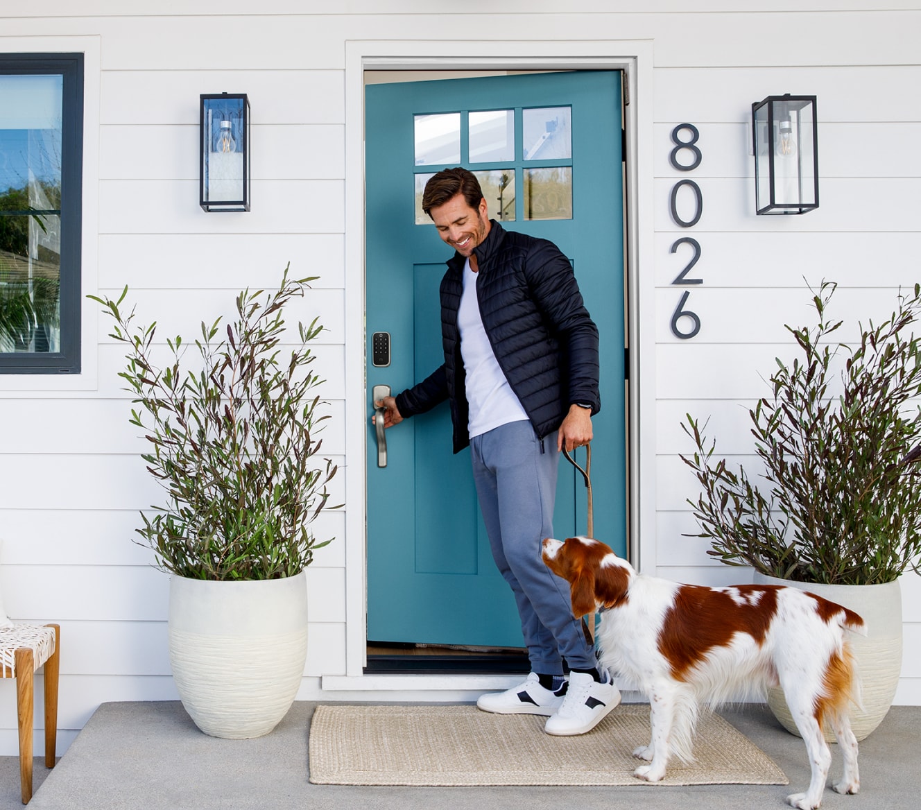 Homeowner with his dog outside of his front door that has a Yale Smart Lock on the door Homeowner with his dog outside of his front door that has a Yale Smart Lock on the door